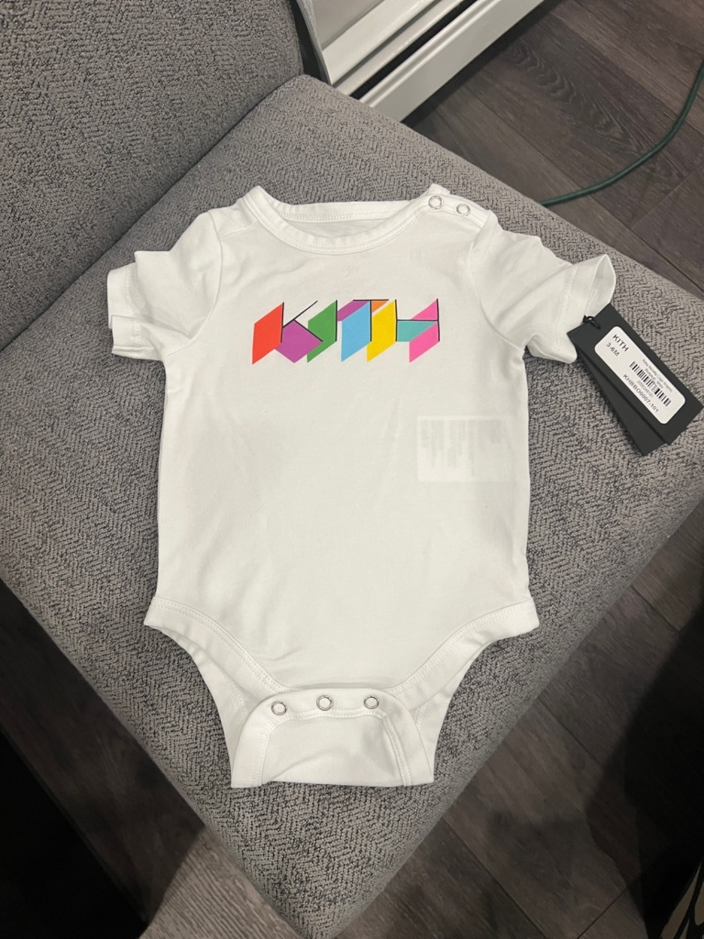 Kith White Baby One-Piece with Multicolor Geometric Logo